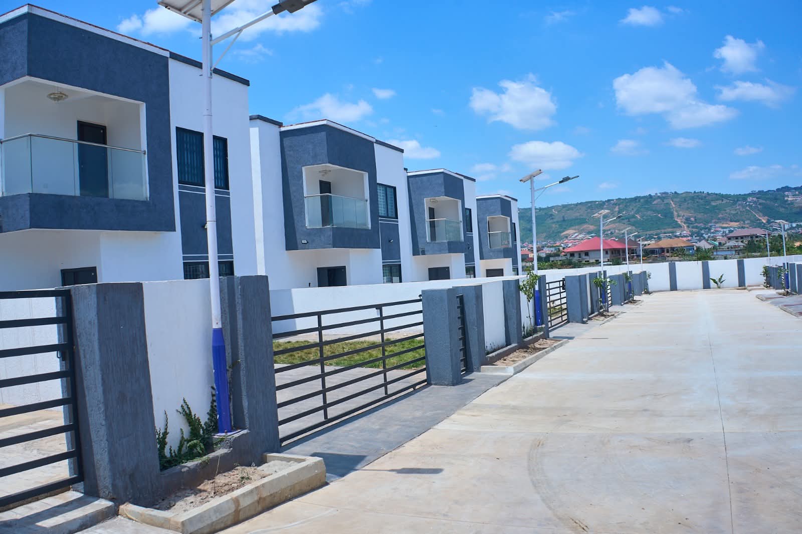 Finished homes with front gates along a paved street